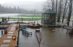 Flooded garden with summer house and garden furniture 